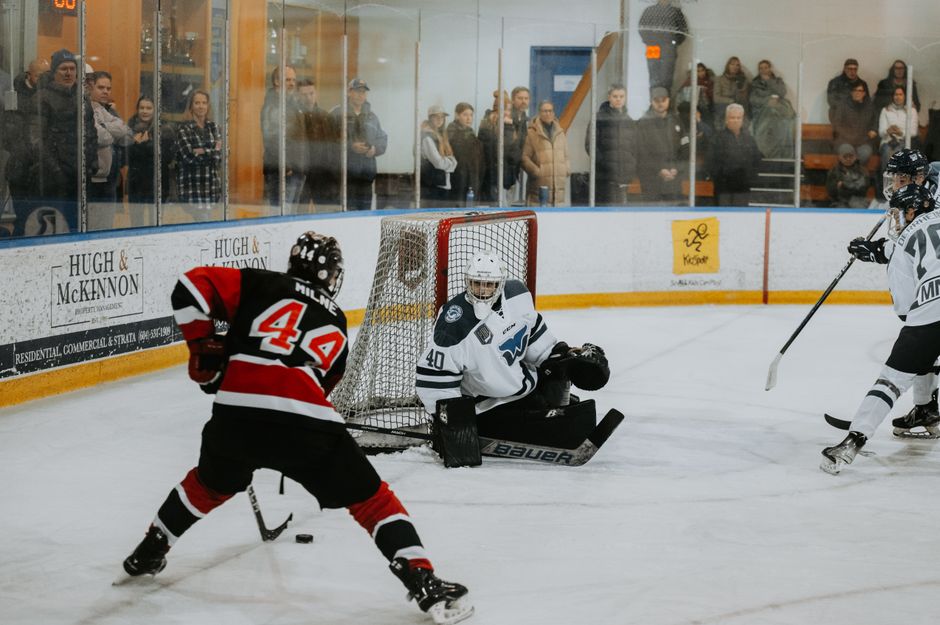 A thrilling hockey game captured indoors with players in action and spectators watching keenly.
