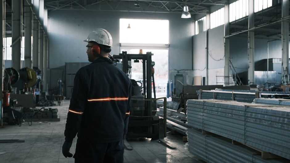 A worker in protective gear supervises operations in a modern Ankara factory.