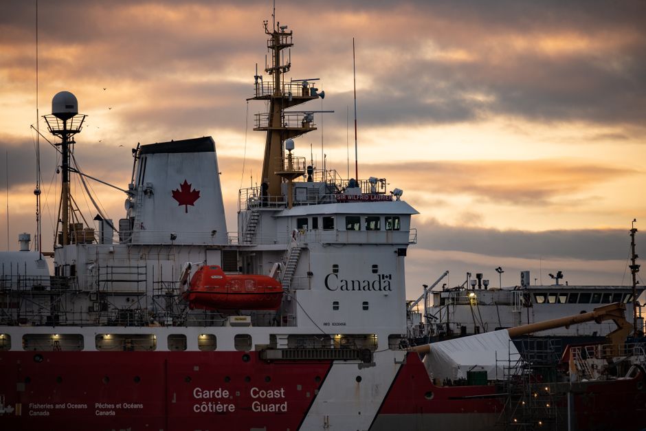 Close-up of a Canadian Coast Guard ship docked at sunset, showcasing maritime details.