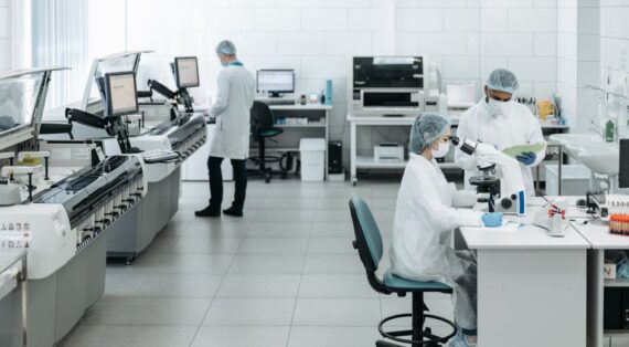Researchers in lab coats performing experiments with advanced equipment in a laboratory.